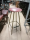 Hire BAR STOOL ROUND RED SEAT +SPLAYED GILT WORN LEGS  + FOOT RESTS.